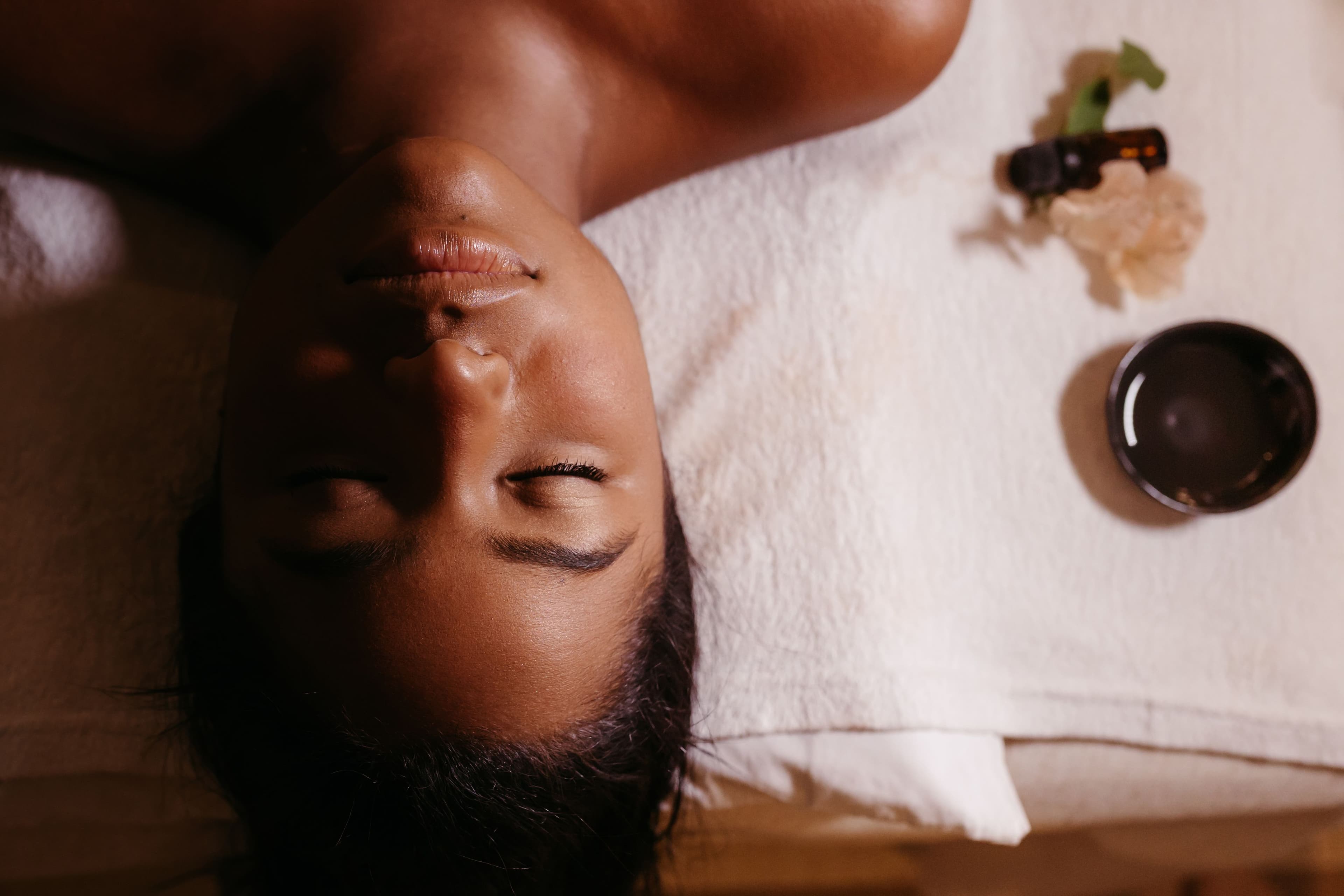 A guest resting on the treatment table beside warmed oils